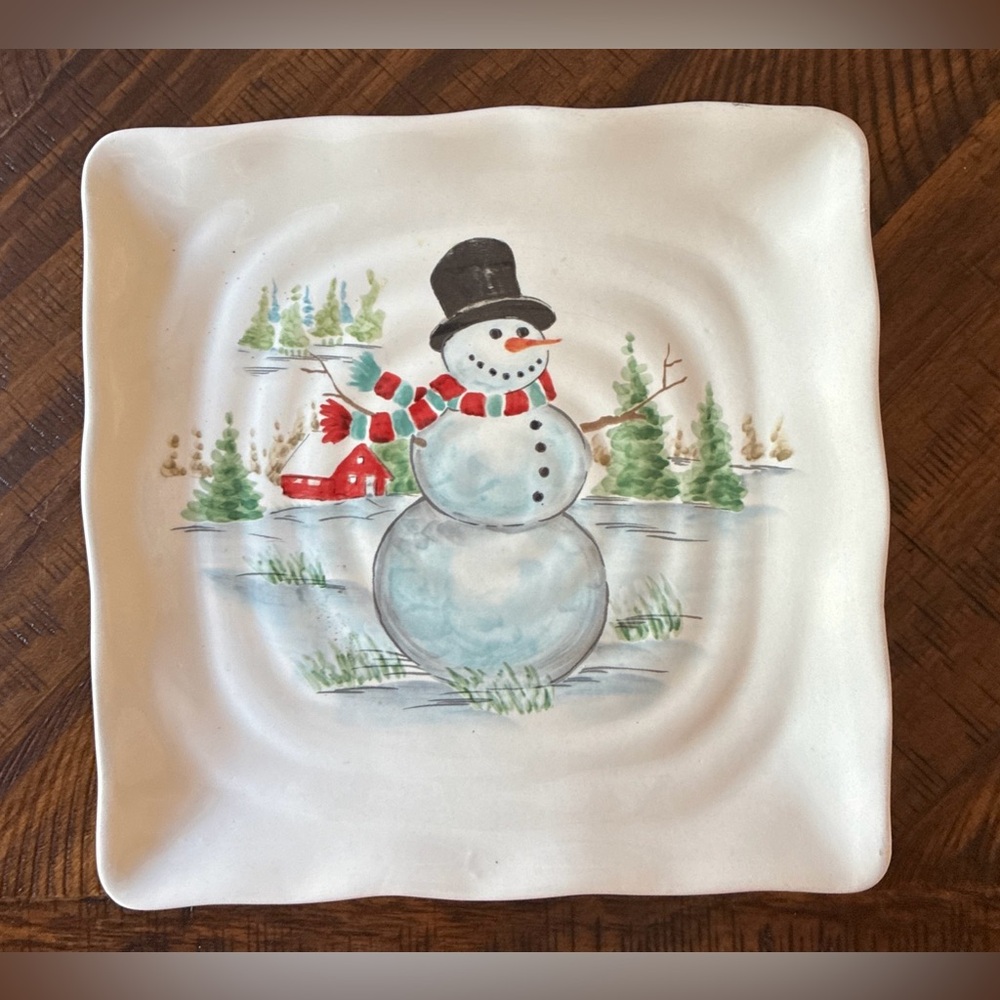 A Maxcera ceramic square plate with a hand-painted snowman winter scene.